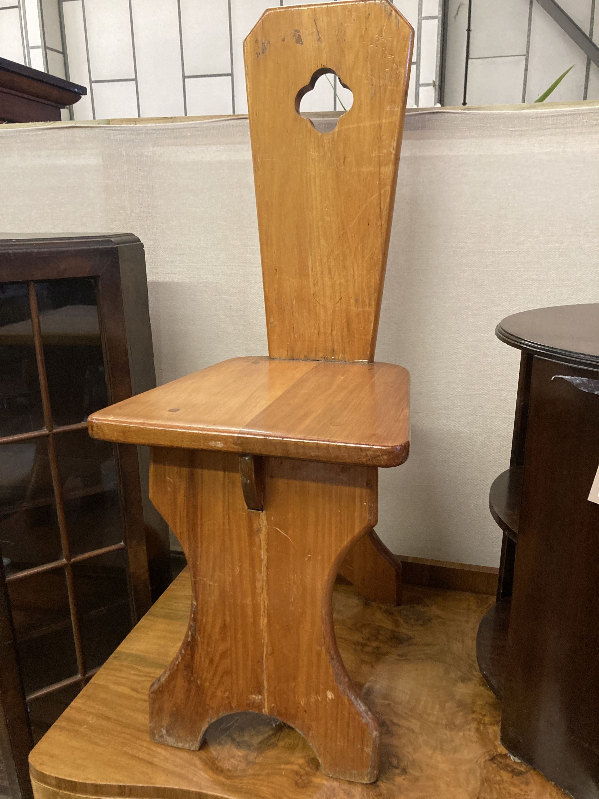 A pair of Italian style pitch pine hall chairs, stamped underneath R.Woolfe and J. Hadaway, width 38cm depth 50cm height 98cm